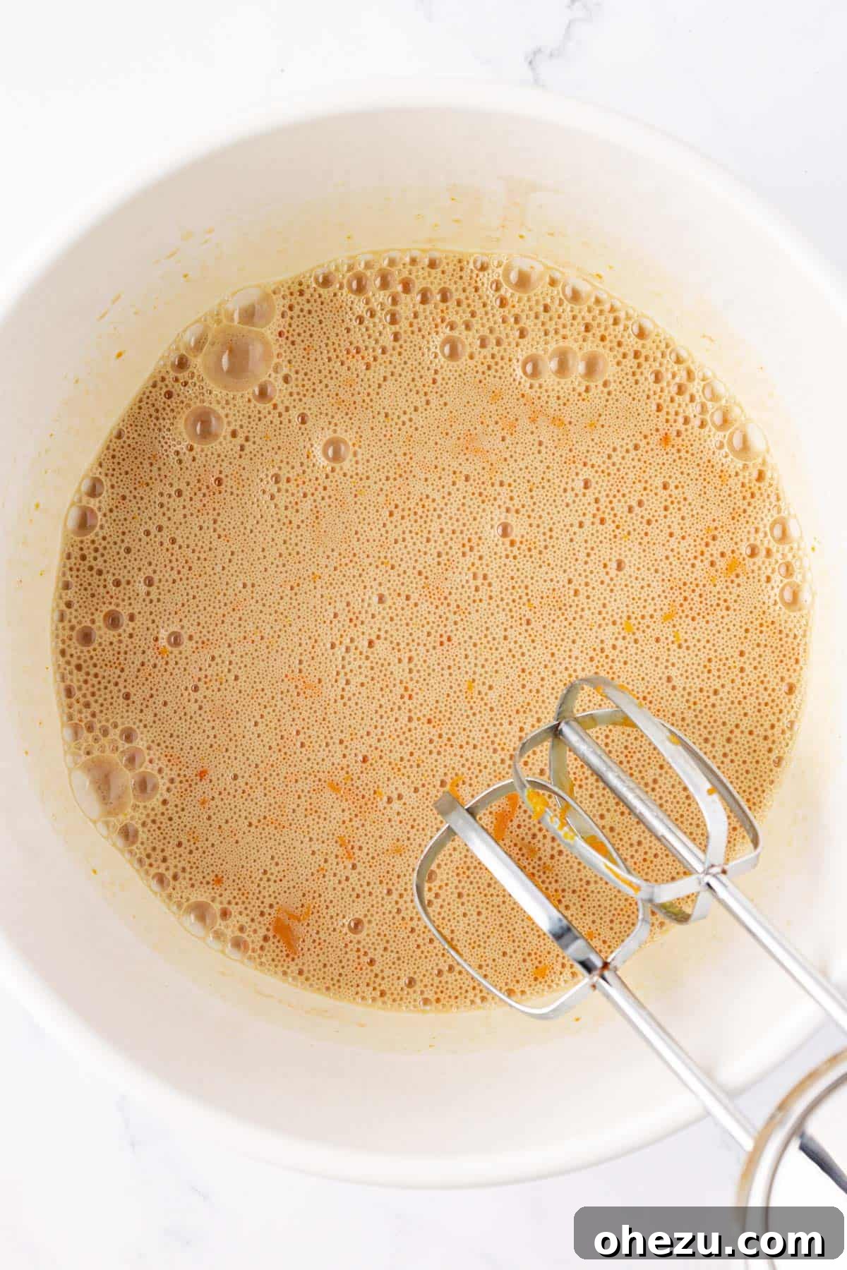 Wet ingredients creamed together smoothly in a mixing bowl, ready for dry ingredients.