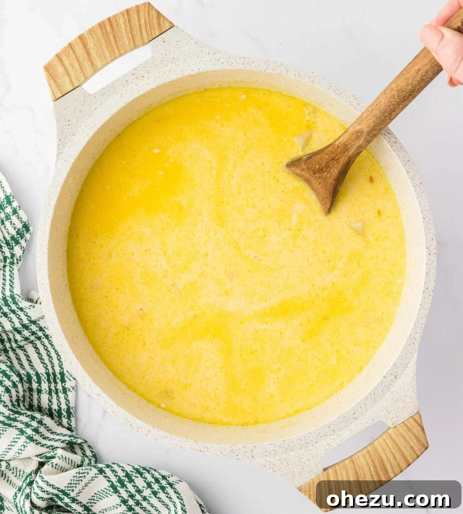 Velvety Potato Warmth 14 A spoon stirring the rich and creamy potato soup in the pot, showcasing its velvety texture.