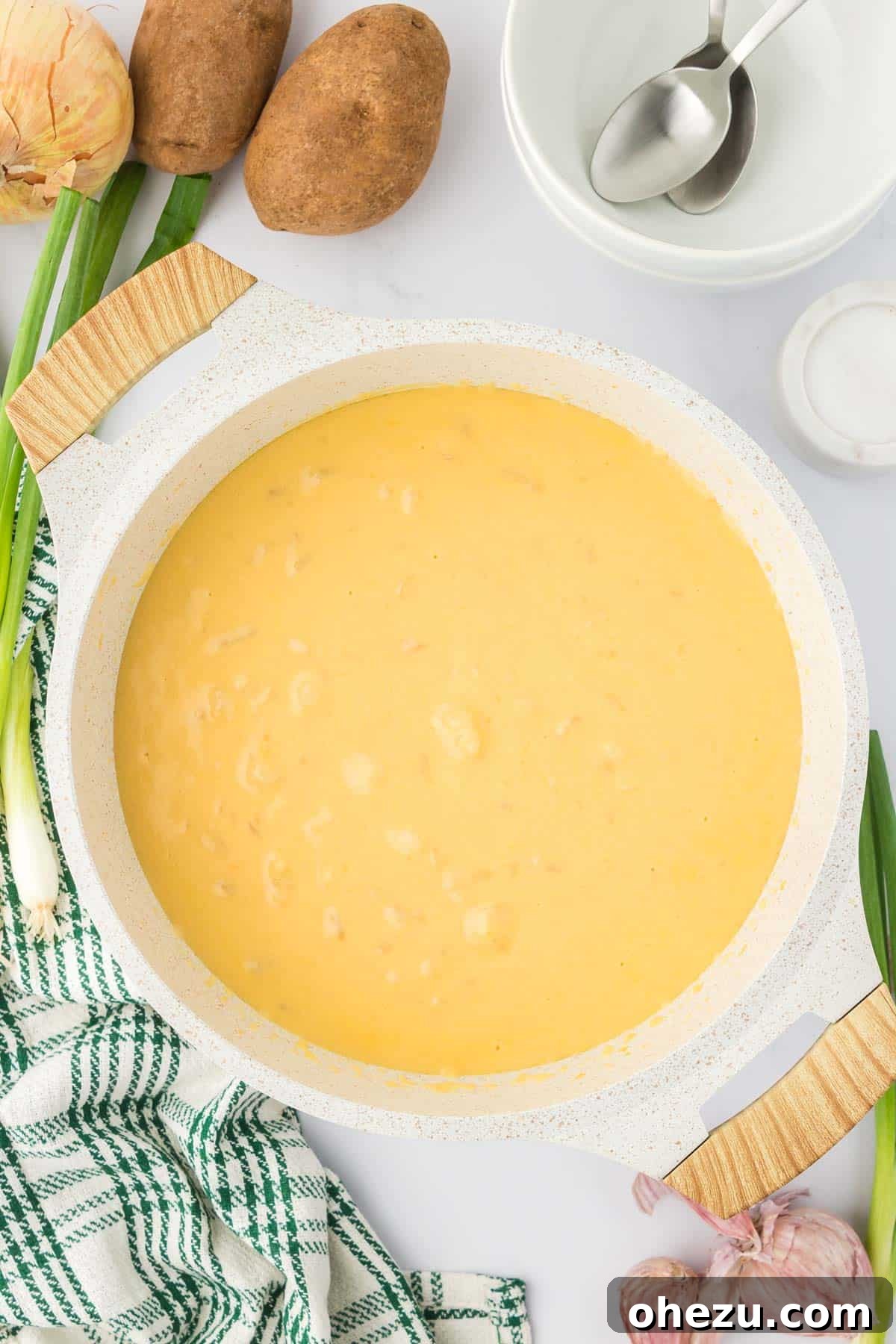Velvety Potato Warmth 16 A large pot filled with steaming vegetarian potato soup, showcasing its golden color and creamy texture.