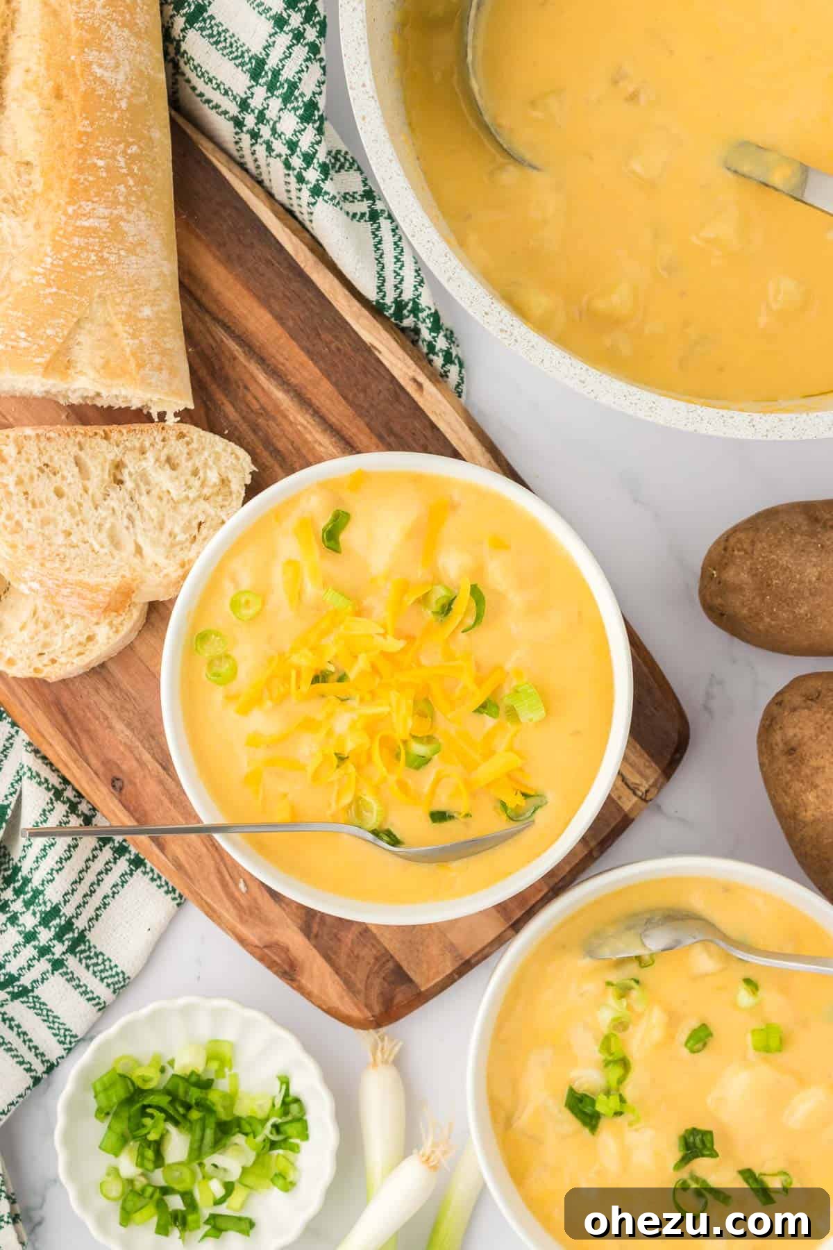 Velvety Potato Warmth 18 A full bowl of potato soup adorned with green onions and cheddar cheese, freshly prepared and ready to be served.