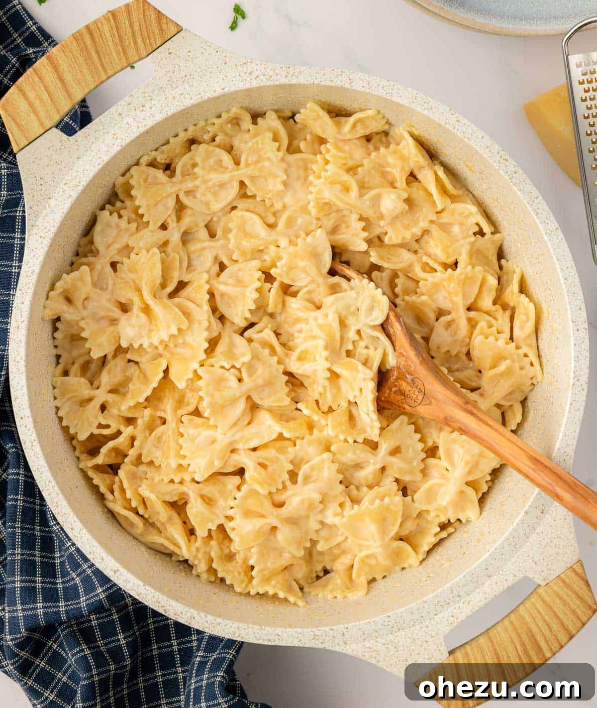 Farfalle Flair 13 A wooden spoon lifting a generous portion of creamy bow tie pasta.