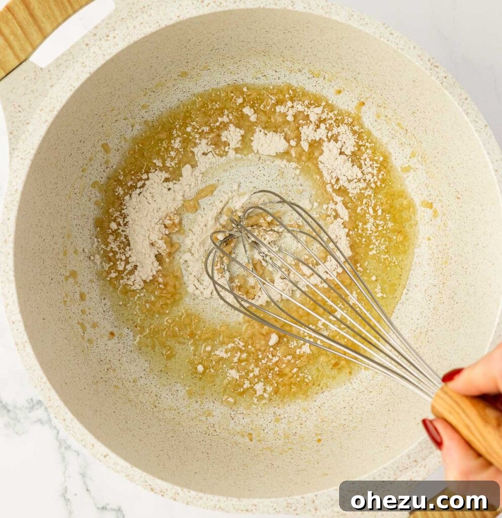 Farfalle Flair 6 Whisking flour into the fragrant butter and garlic mixture to form a roux.