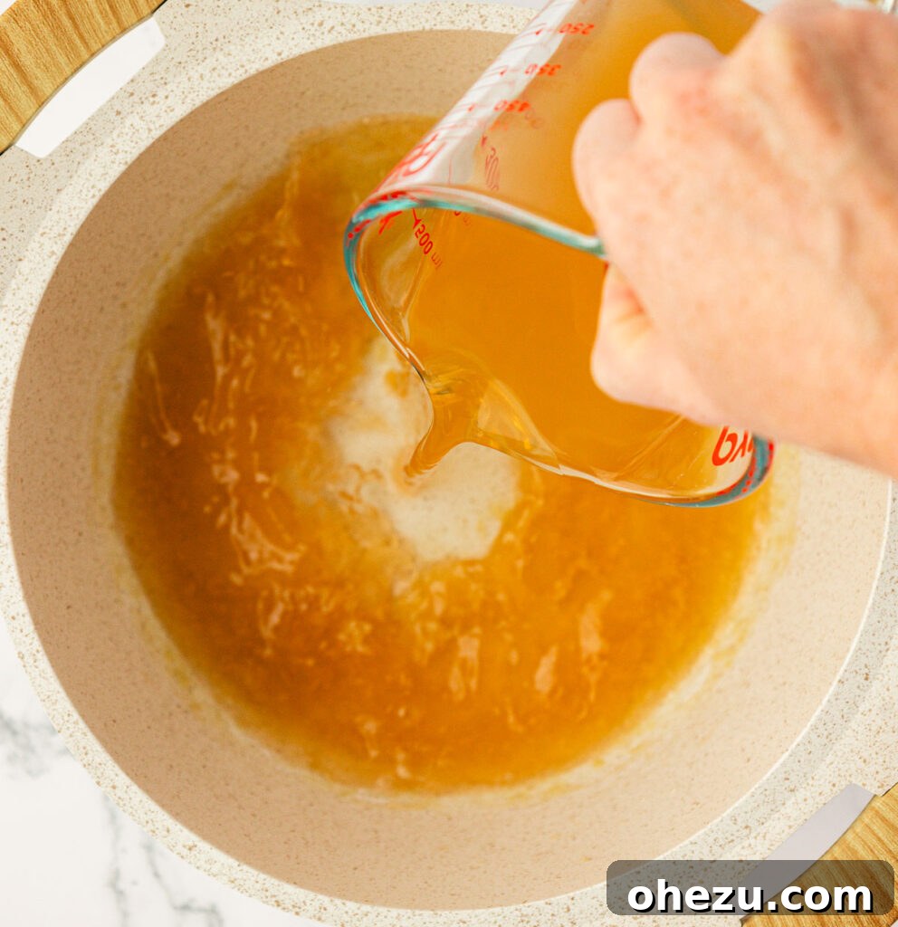 Farfalle Flair 8 Pouring vegetable broth into the saucepan with the roux.