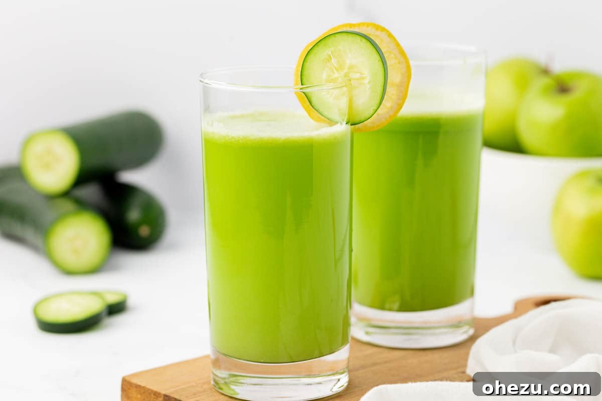 A refreshing glass of cucumber juice garnished with both a cucumber slice and a lemon slice, highlighting its delightful blend.