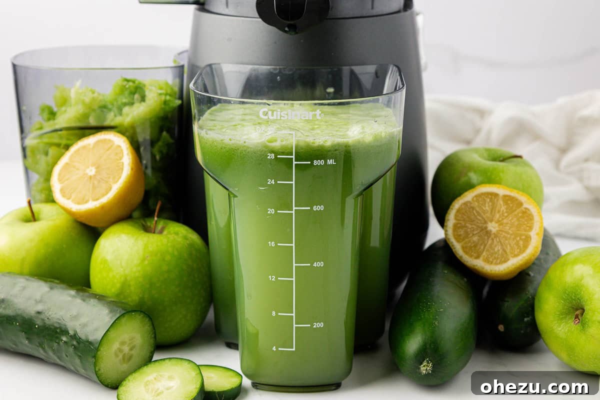 Freshly squeezed cucumber juice poured into a glass, with a juicer visible in the background, highlighting the ease of preparation.