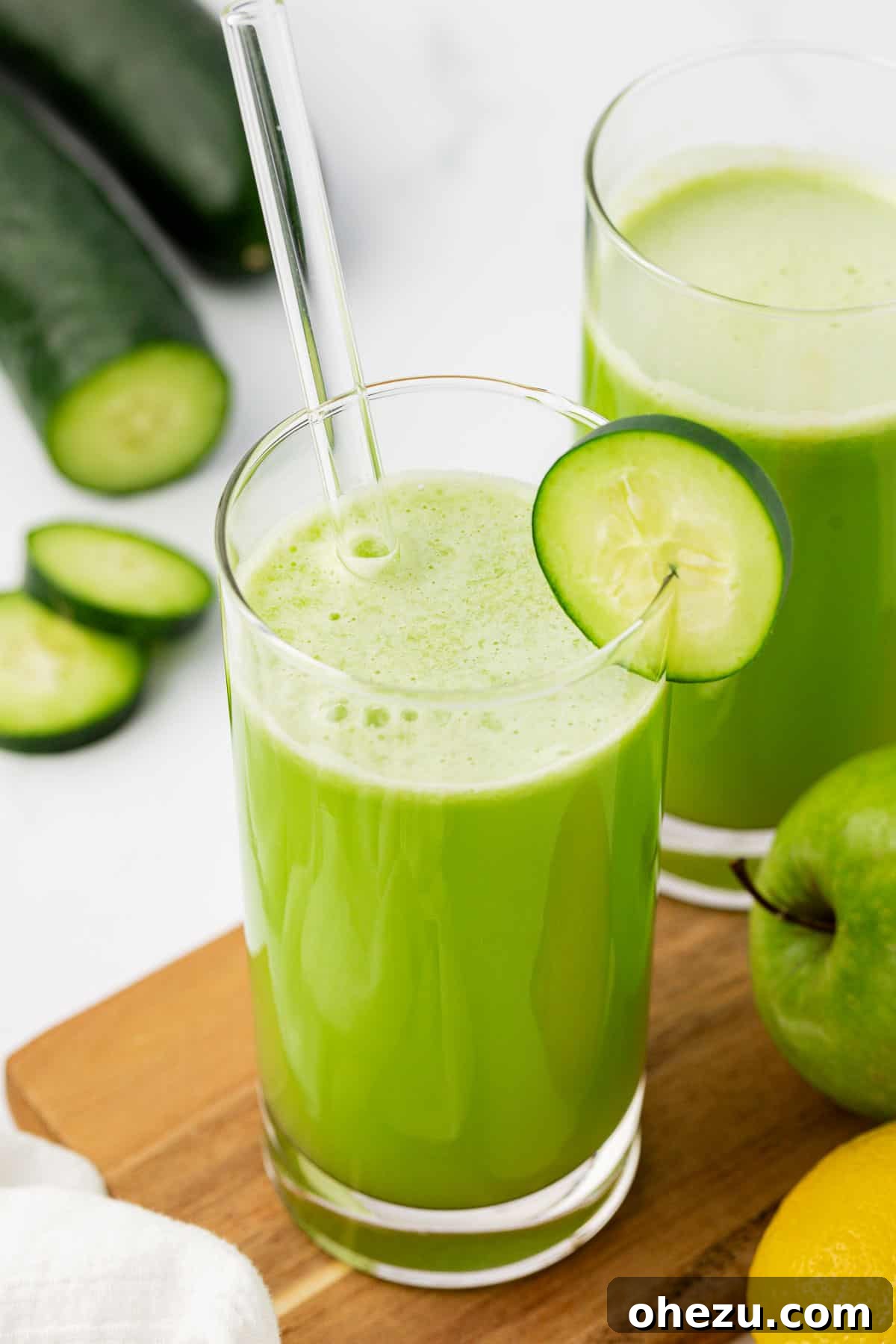 A beautifully presented glass of cucumber juice, garnished with a cucumber slice and a lemon wedge, ready to be enjoyed.