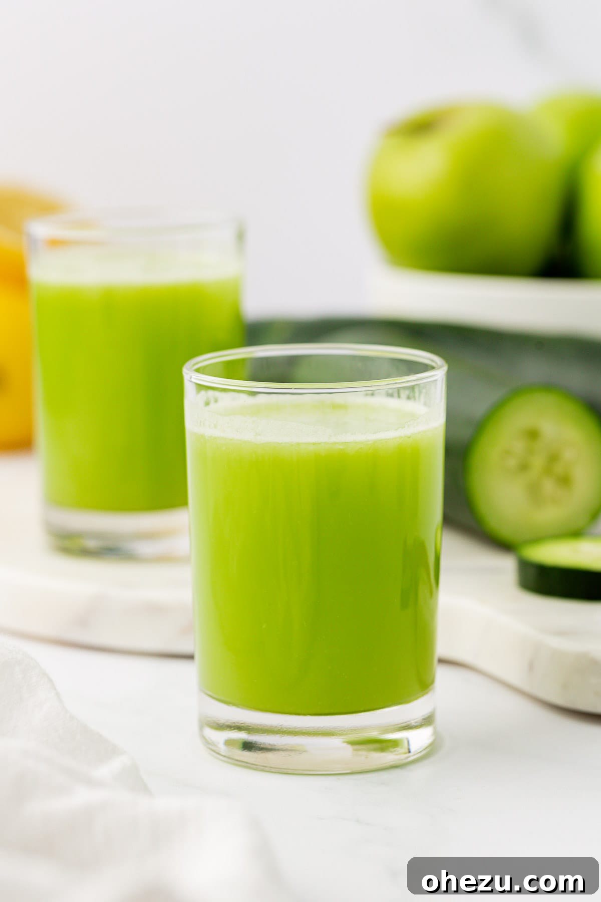 A simple yet elegant shot of cucumber juice in a clear glass, emphasizing its natural, vibrant green color.