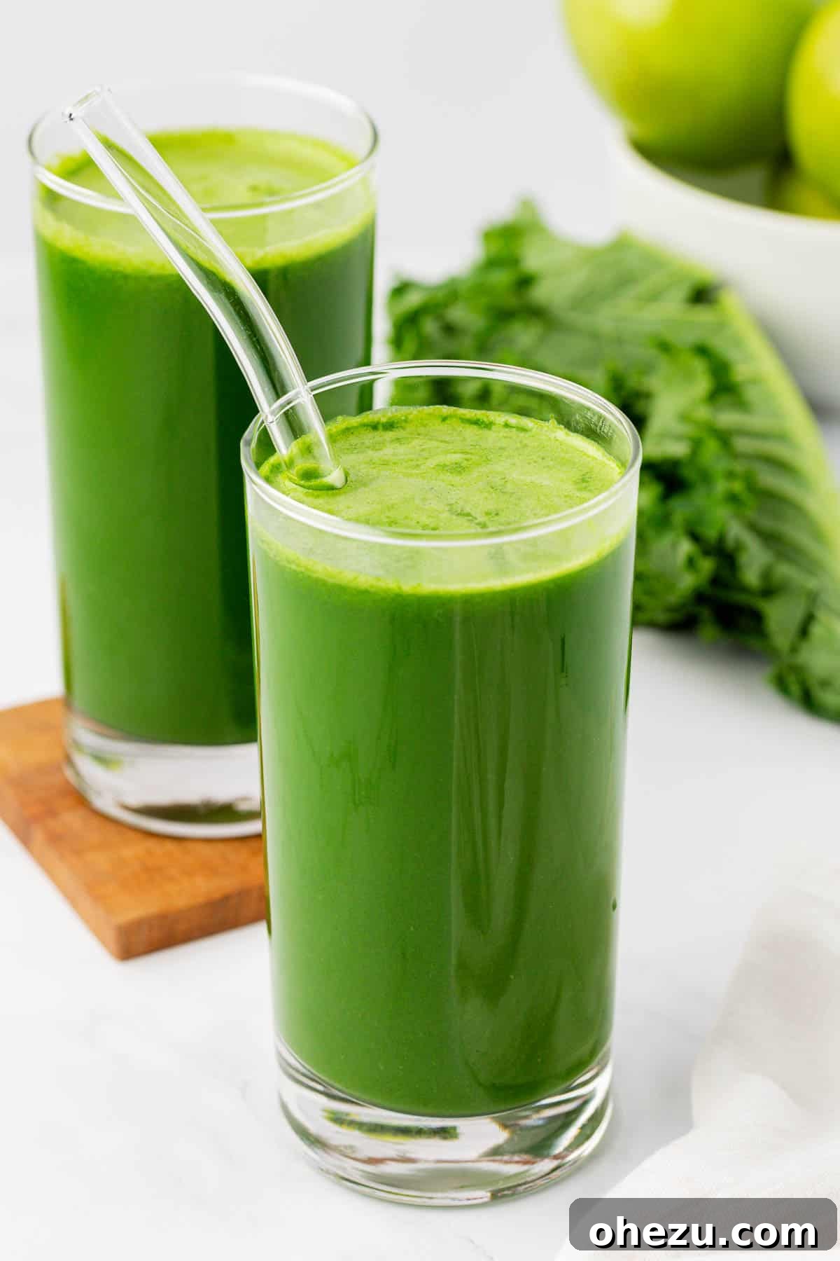 kale juice in a glass with a straw