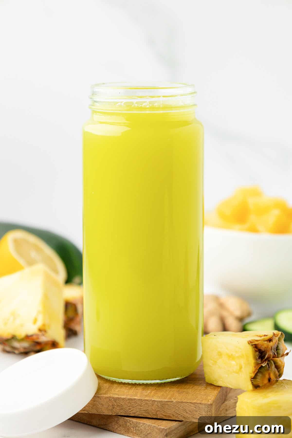 A glass of pineapple cucumber juice with a lid, prepared for storage in the refrigerator
