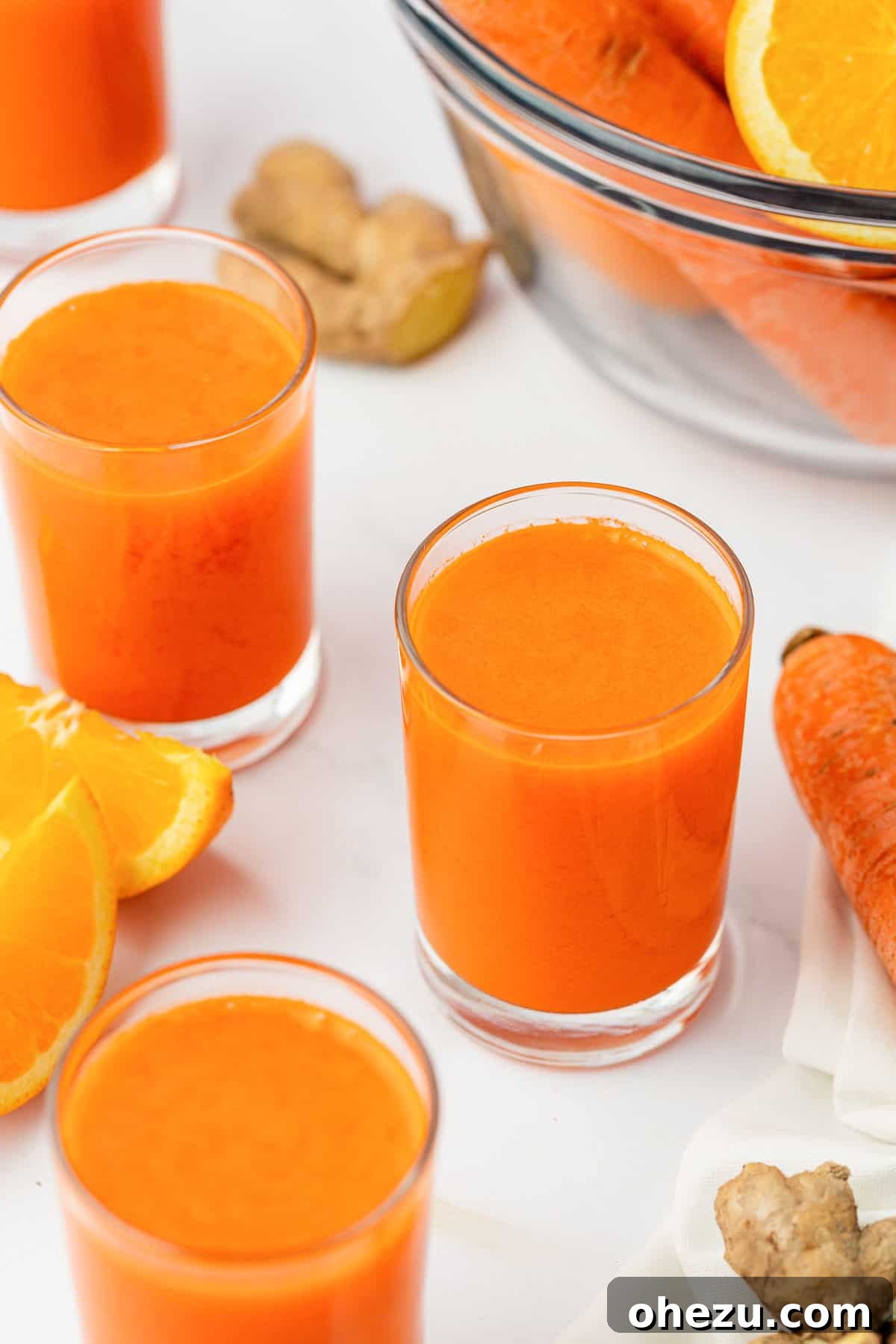 A single glass of bright orange carrot juice, signifying health and refreshment