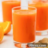 A close-up of vibrant homemade carrot juice in a glass, ready to be enjoyed