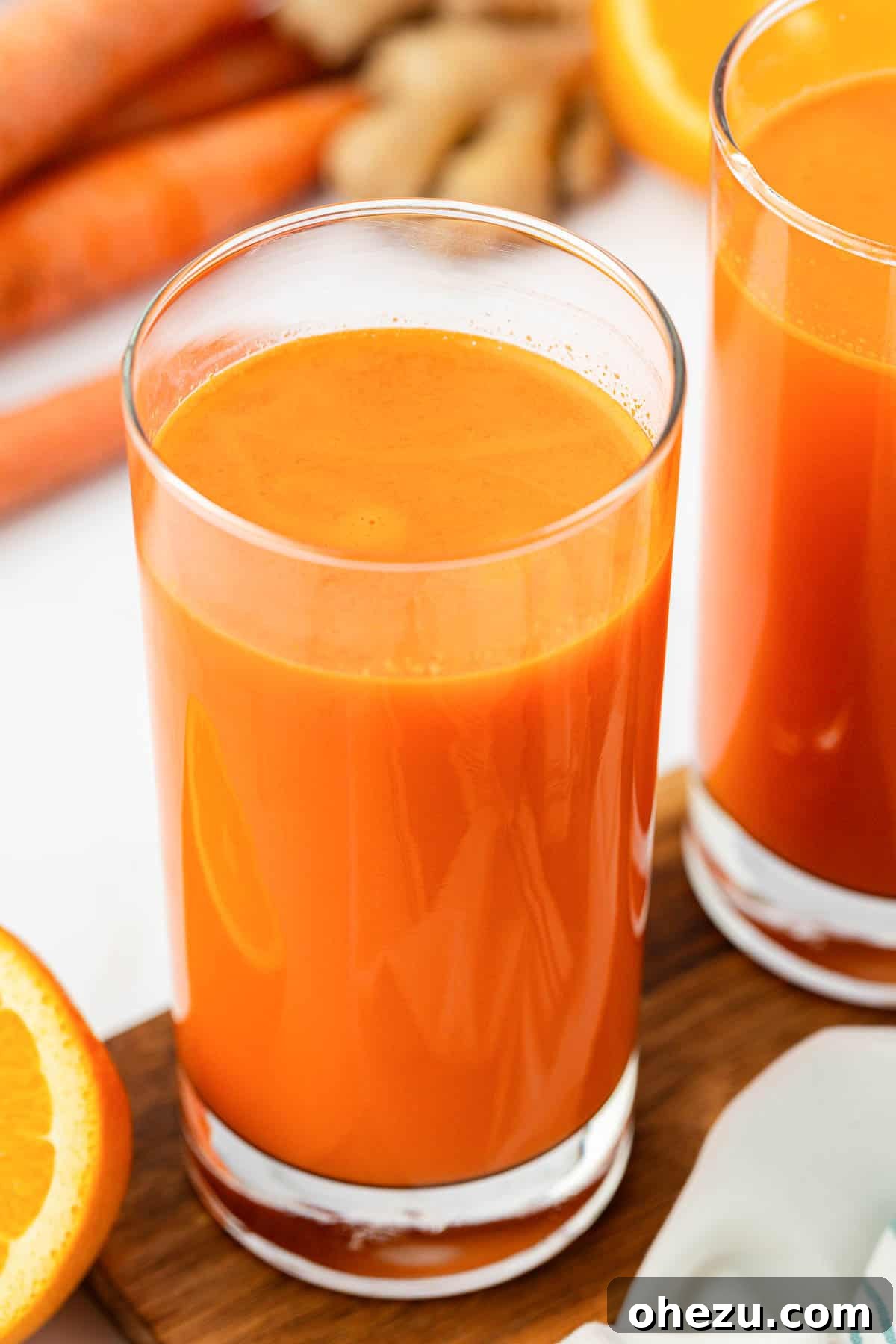 A close-up shot of a glass filled with radiant orange carrot juice, highlighting its fresh and healthy appearance