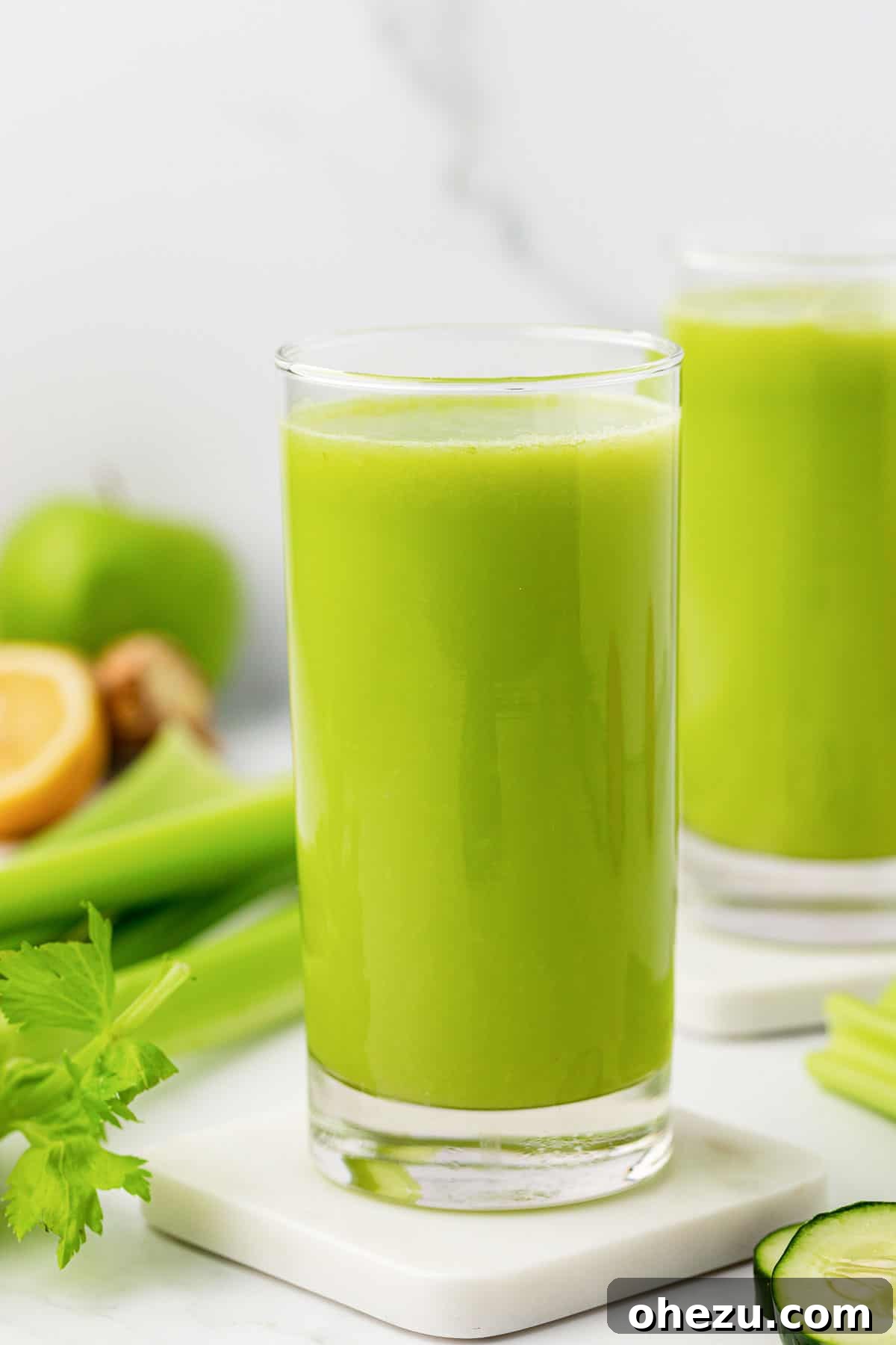 celery juice in a glass, with fresh celery stalks in the background
