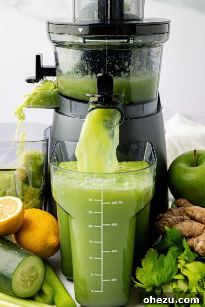 celery juice pouring out of a juicer into a pitcher