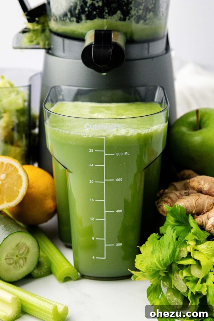celery juice next to a juicer, with fresh ingredients