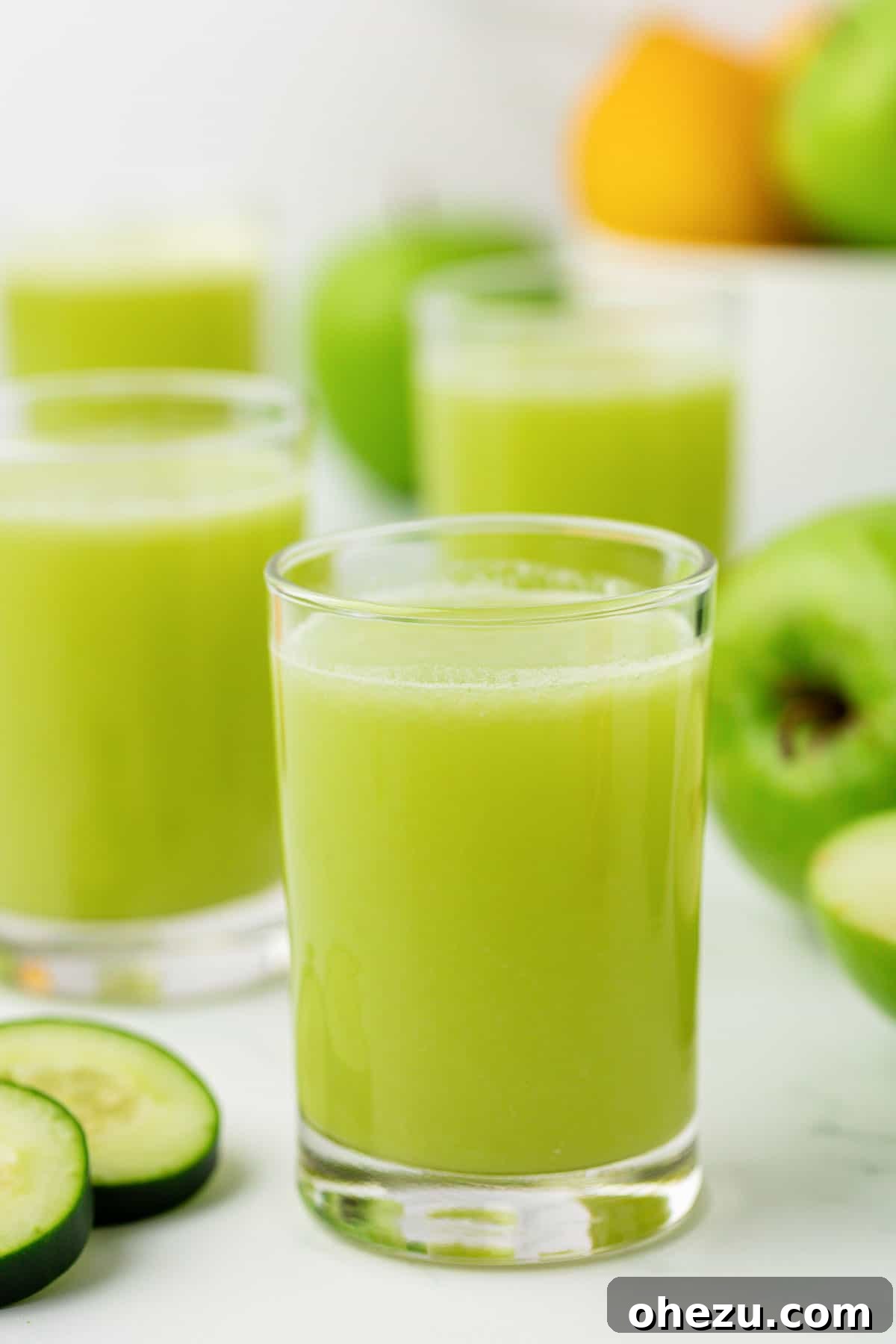 Vibrant green apple juice in a clear glass, glistening with freshness