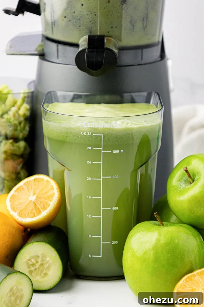 Close-up view of vibrant green apple juice collected in a juicing canister