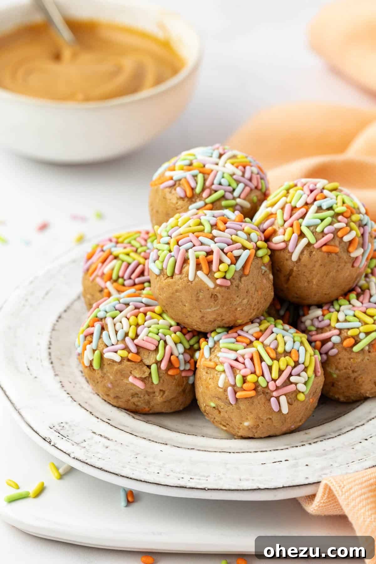 Delicious Birthday Cake Protein Balls covered in colorful sprinkles, arranged on a rustic wooden surface.