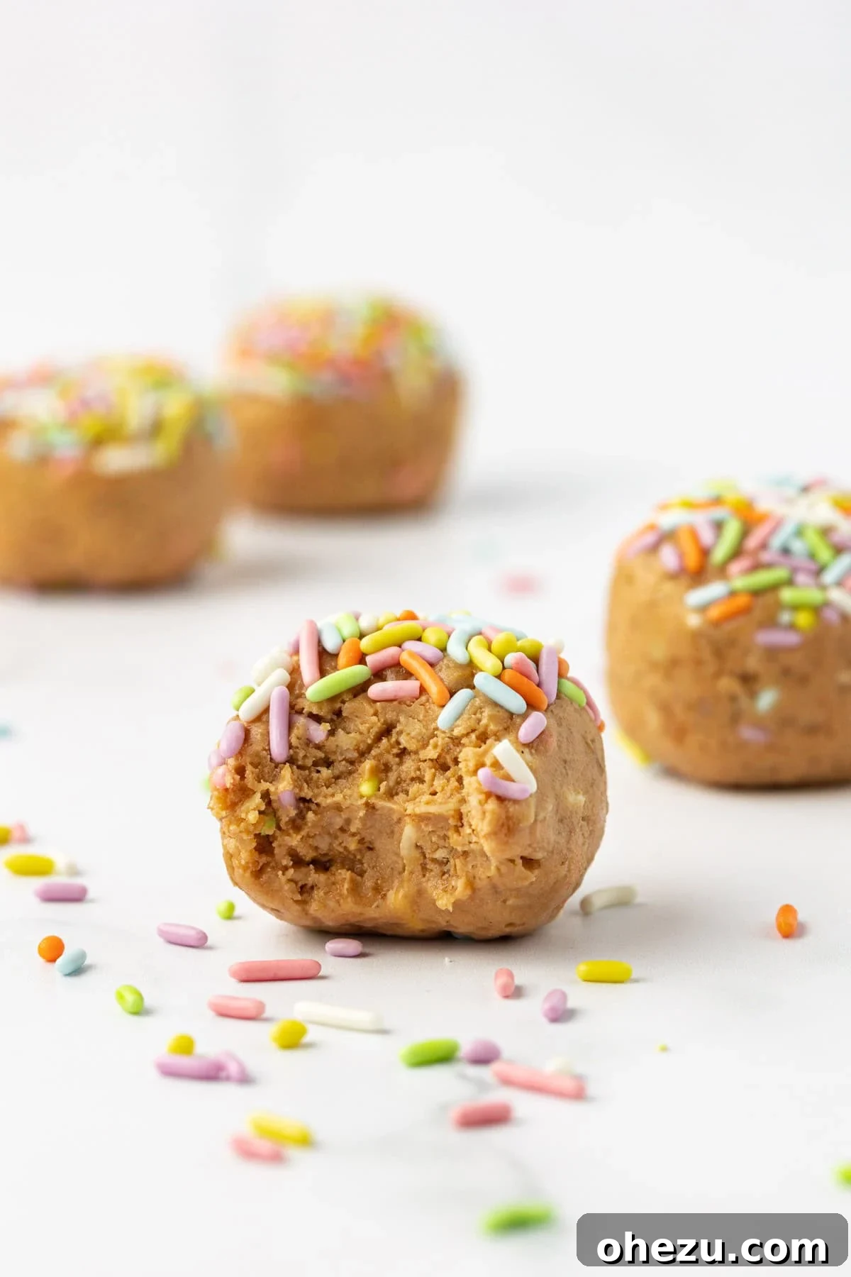 A top-down view of a single Birthday Cake Protein Ball, highlighting its texture and sprinkle coating.