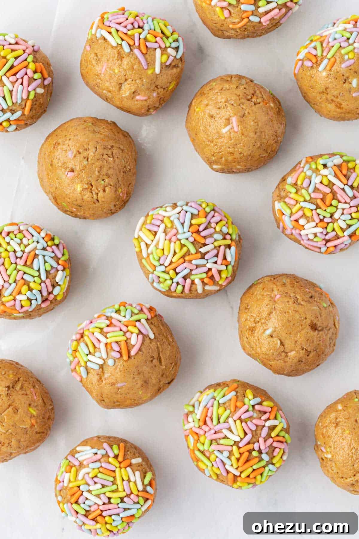 A single Birthday Cake Protein Ball held up, highlighting its perfect shape and sprinkle coating.