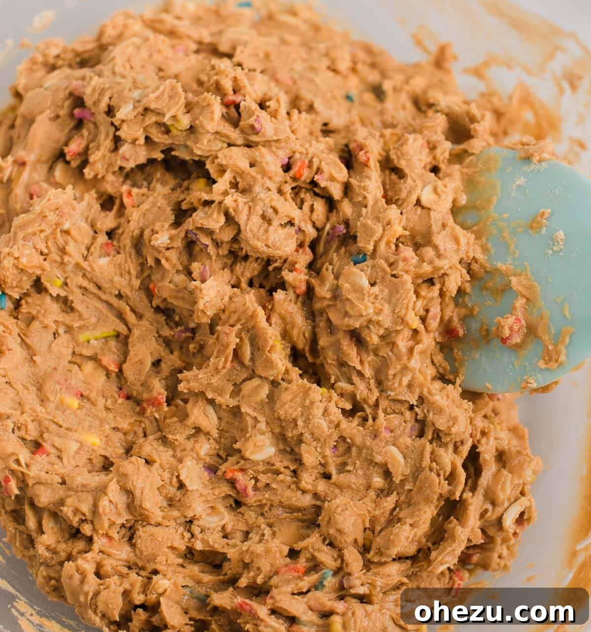 The mixed birthday cake protein ball batter in a mixing bowl, showing a thick, cohesive texture.