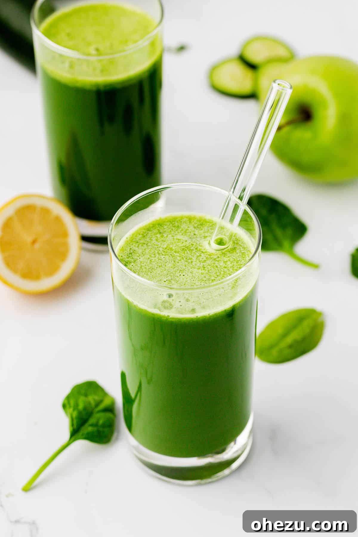 Green Vitality Boost 2 Freshly pressed spinach juice in a glass with a straw, garnished with a spinach leaf.