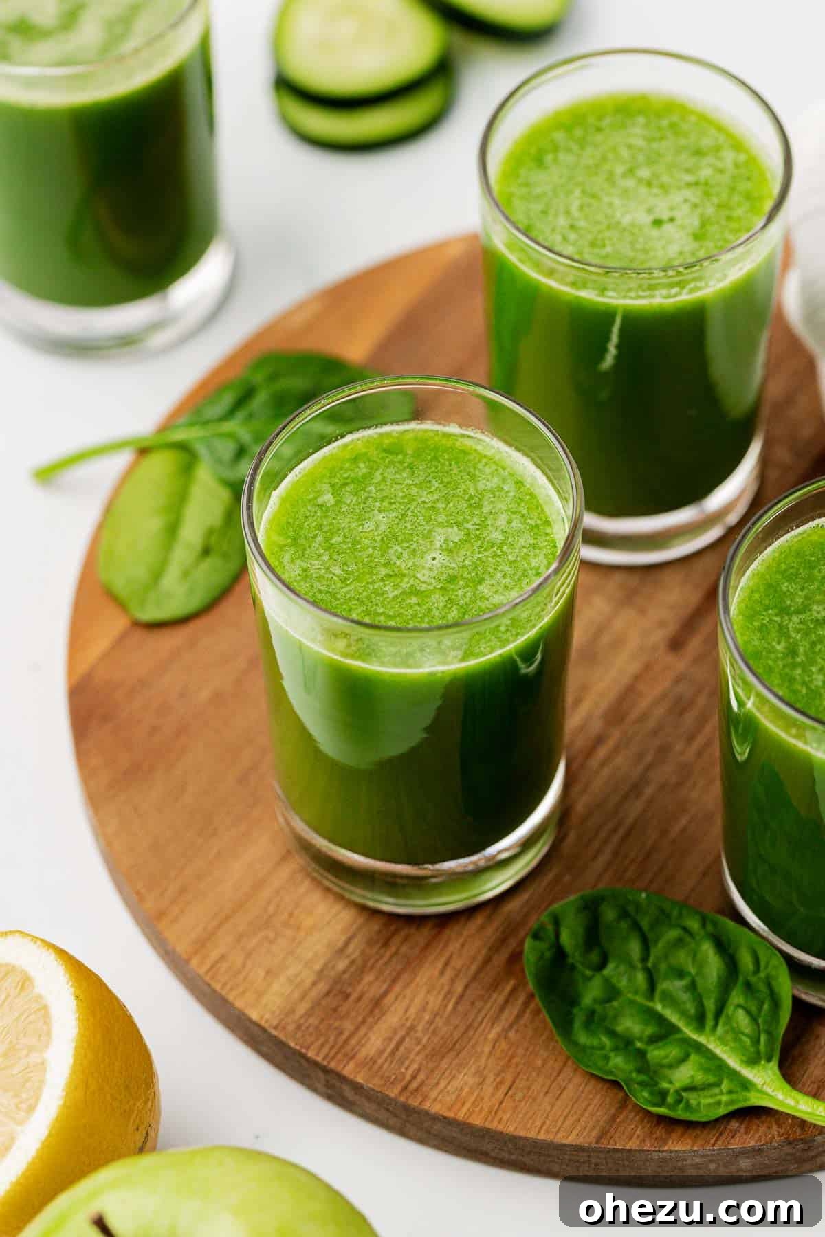 Green Vitality Boost 8 A glass of vibrant green spinach juice resting on a rustic wooden cutting board with a few fresh spinach leaves for garnish.