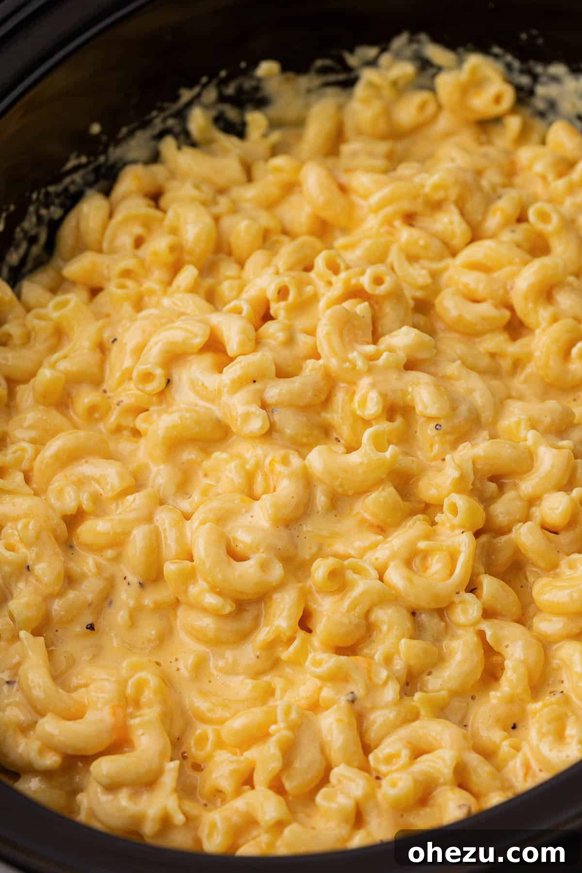 Creamy Slow Cooker Mac and Cheese 16 An appetizing close-up of the rich, golden, and creamy texture of the cooked mac and cheese in a bowl.