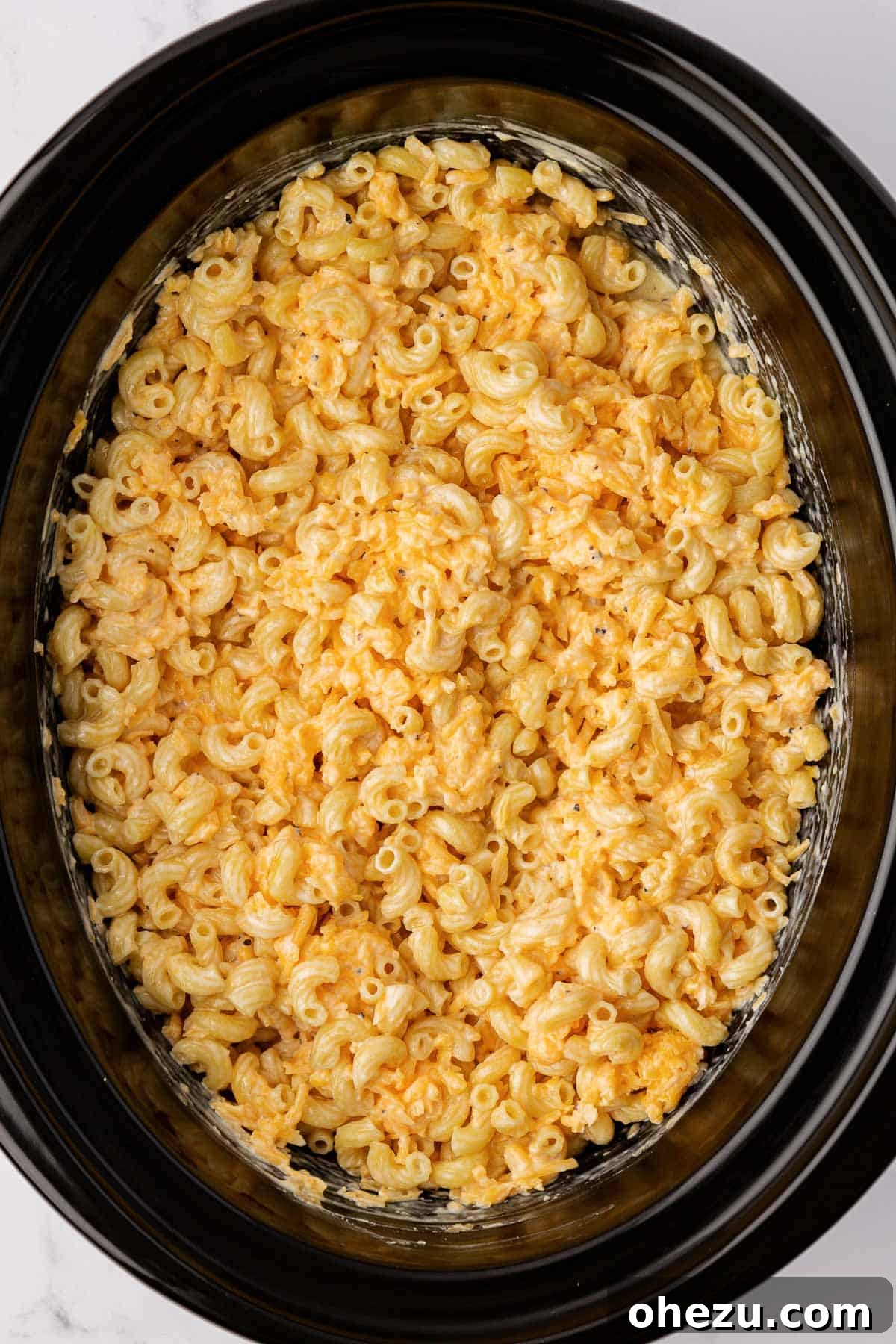 Creamy Slow Cooker Mac and Cheese 7 All ingredients for mac and cheese thoroughly mixed together in a slow cooker before cooking, showing a smooth, consistent base.