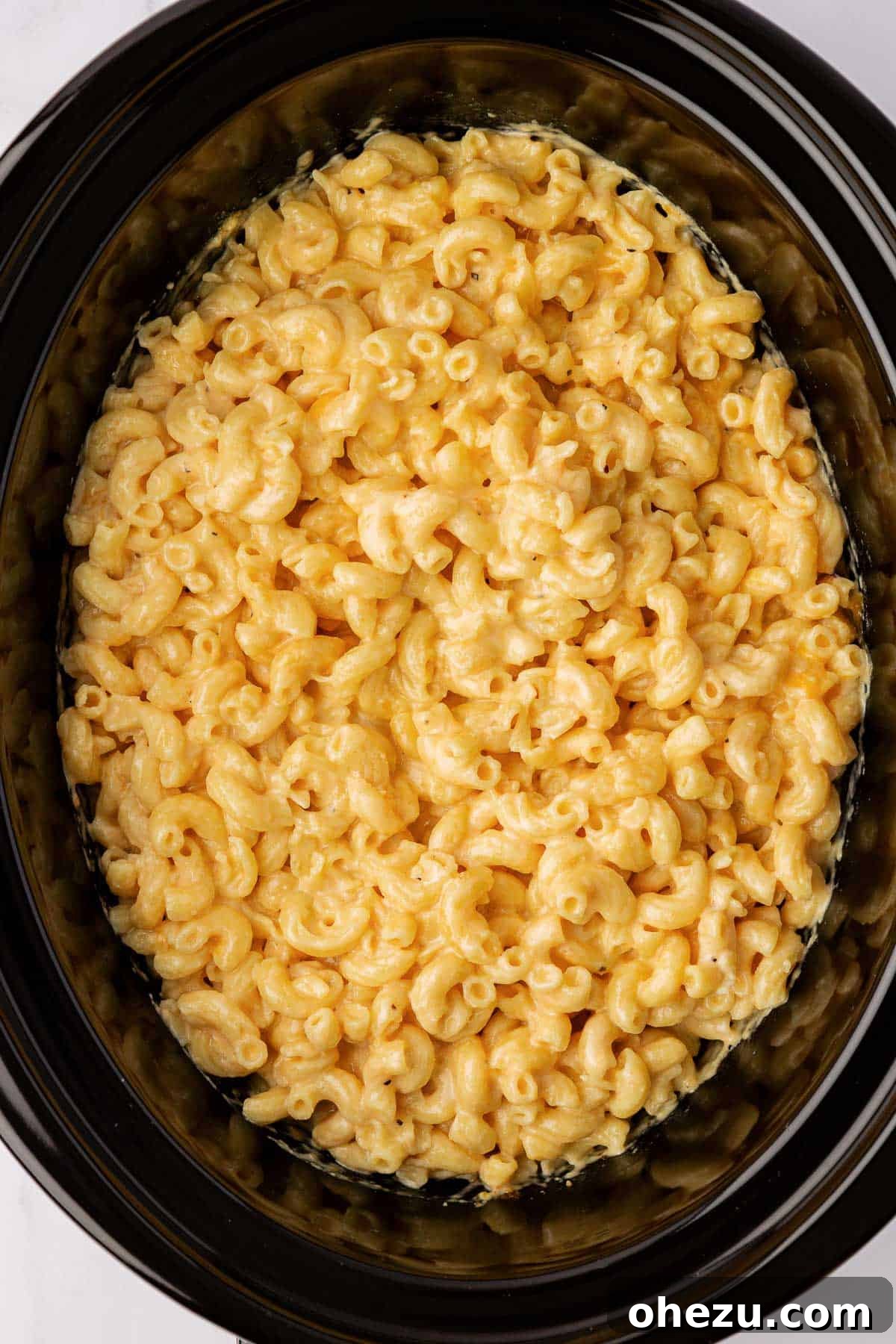 Creamy Slow Cooker Mac and Cheese 8 A closer view of the creamy mac and cheese mixture in the slow cooker, ready for the cooking process.