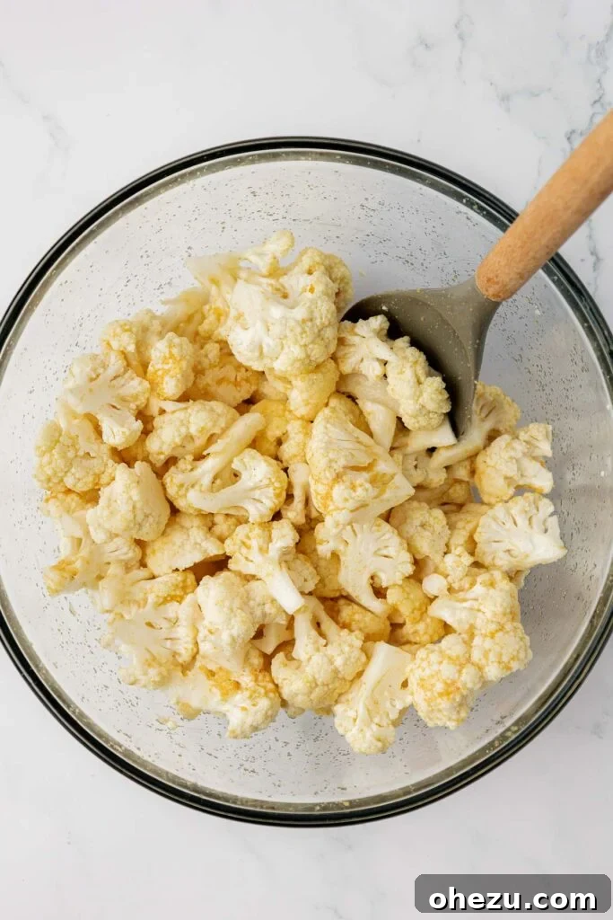 stirring the spices and oil into the cauliflower florets in a mixing bowl