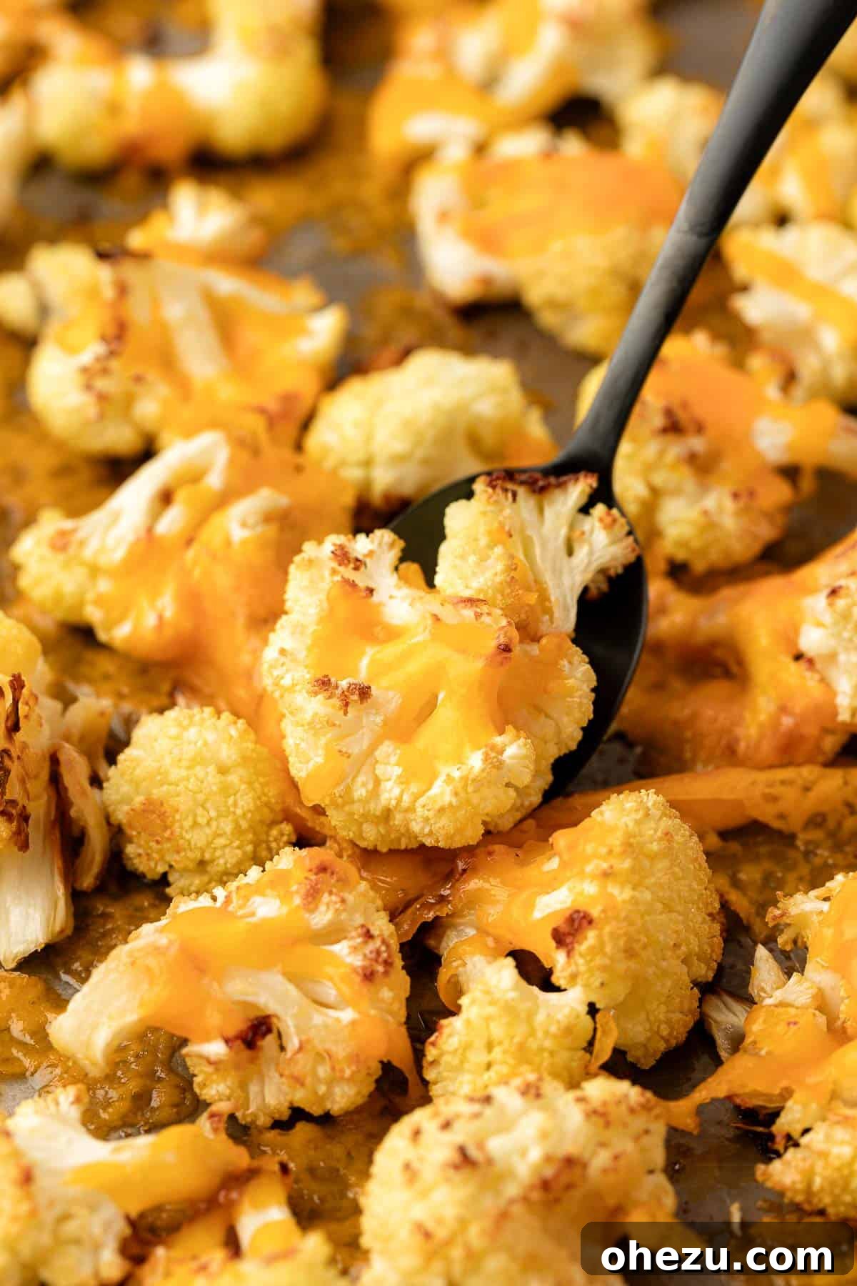 roasted cheesy cauliflower on a baking sheet after being reheated or freshly made