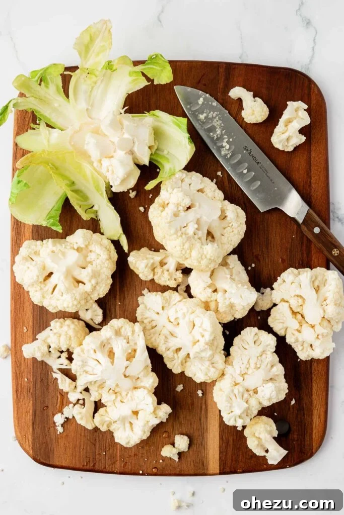 cutting cauliflower on a cutting board into florets
