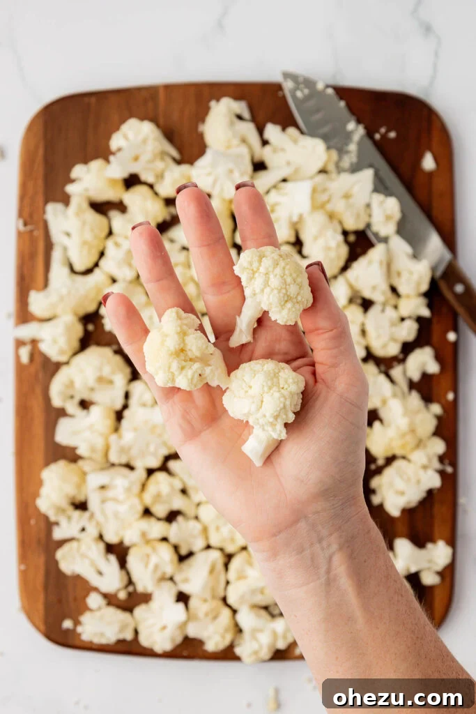 hand holding a cauliflower floret to show the ideal bite-size