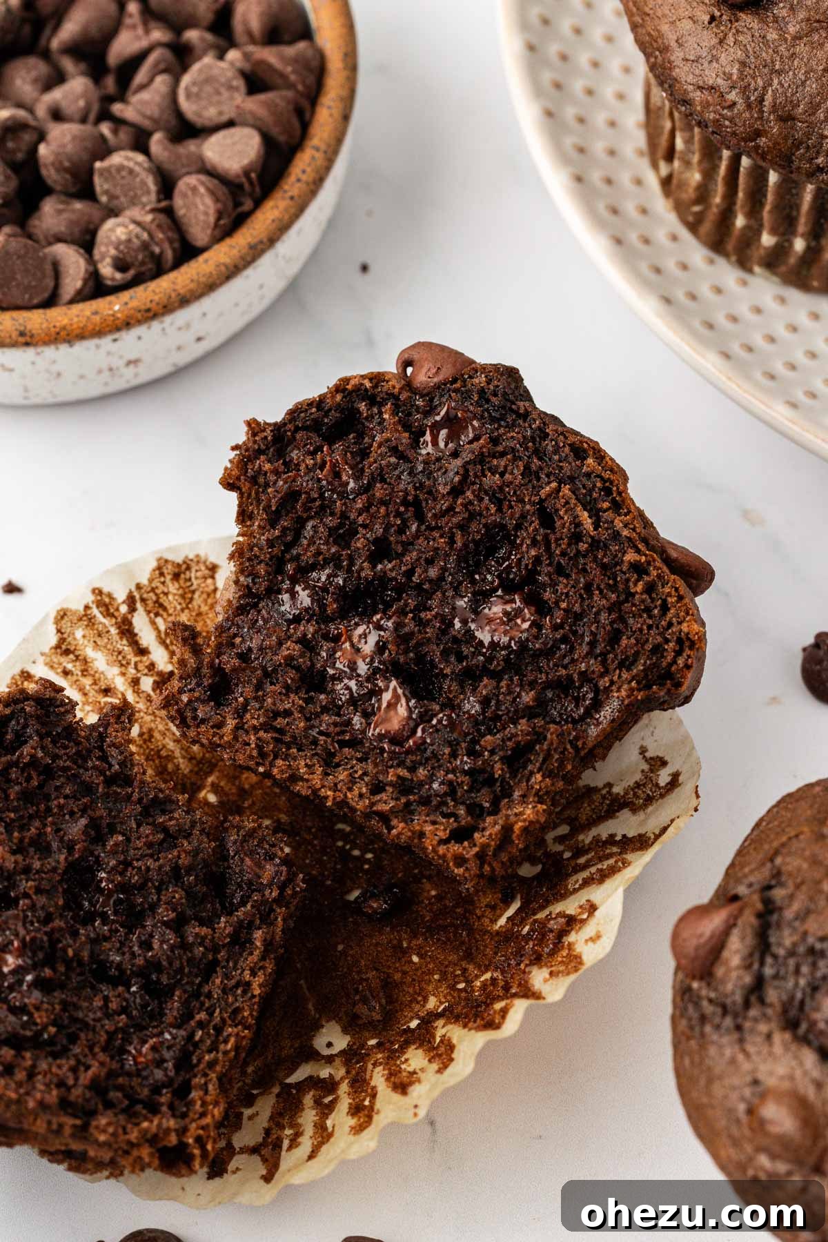 A perfectly baked double chocolate cake mix muffin, cut in half to show its moist, dense crumb and abundant chocolate chips.