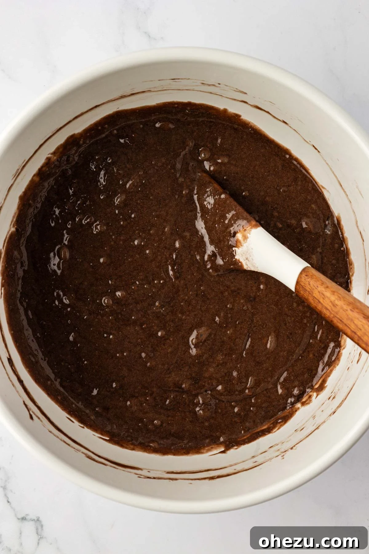 The smooth, dark chocolate cake mix muffin batter resting in a mixing bowl, ready for chocolate chips.
