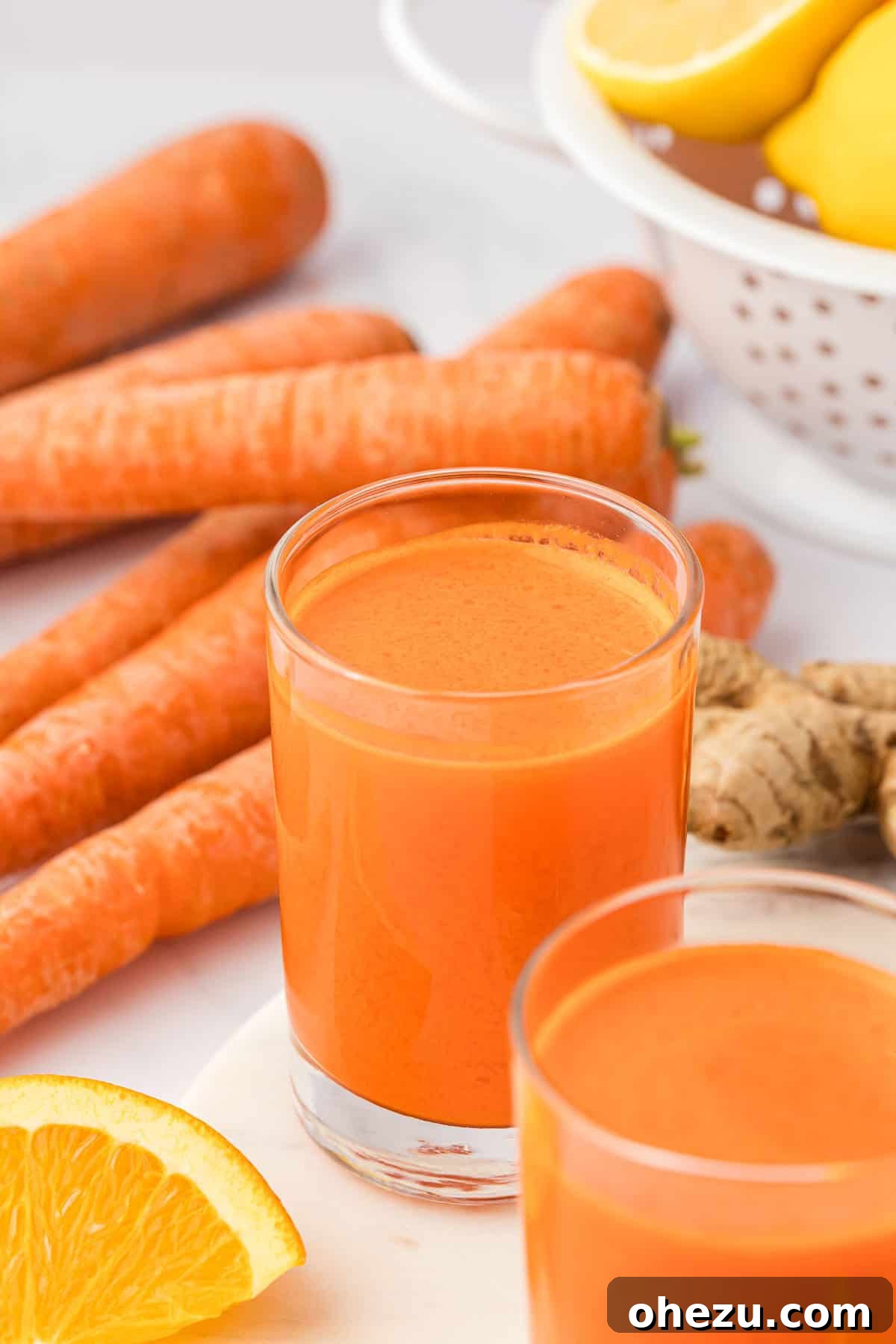 A refreshing glass of carrot orange ginger juice on a light background, emphasizing its natural vibrancy.