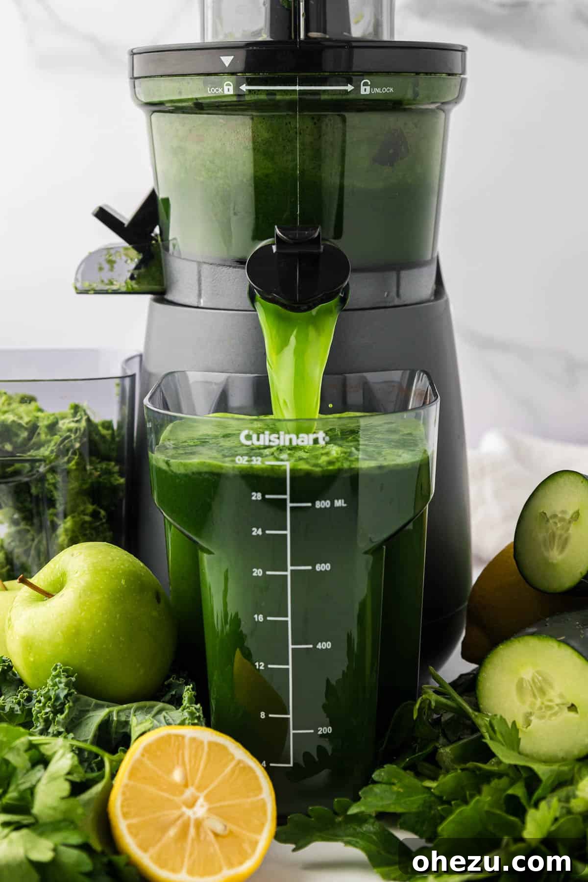 Vibrant green juice pouring out of a home juicer into a collection pitcher