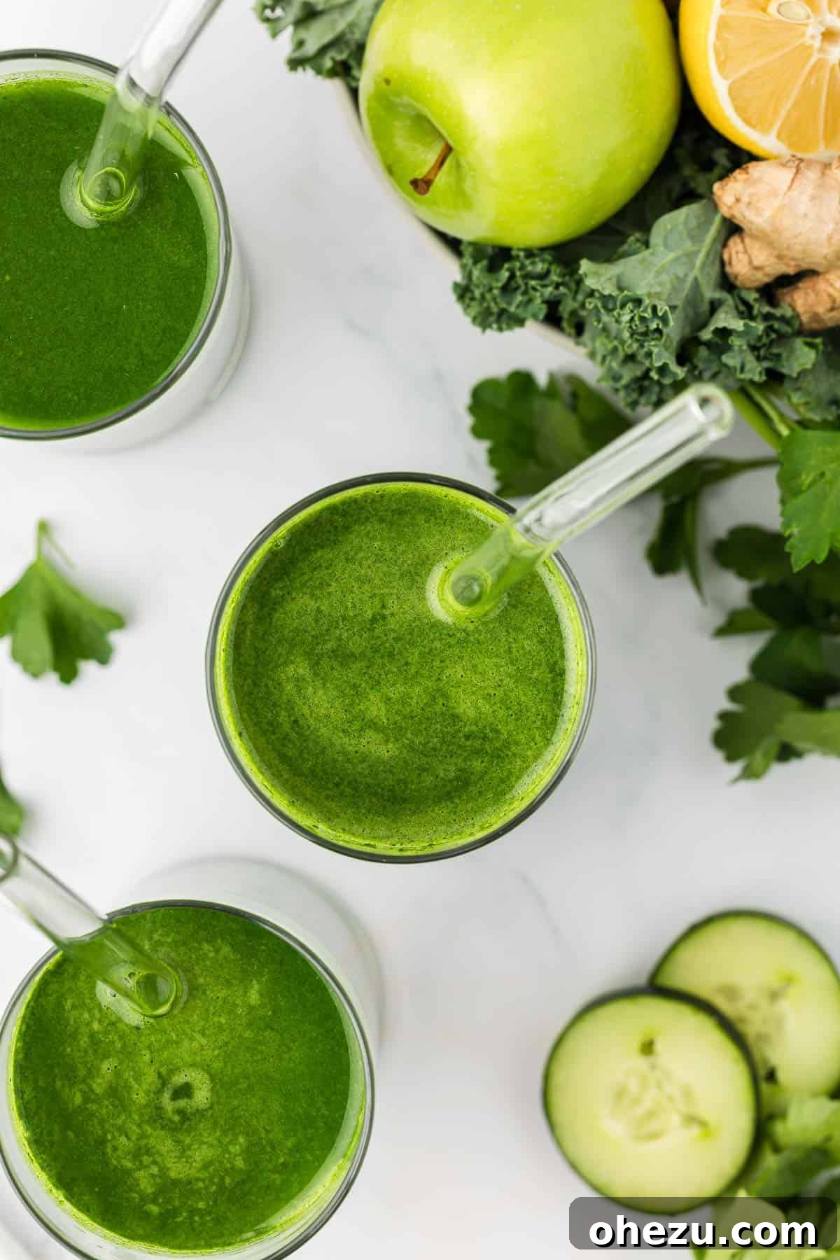 A glass of vibrant vegetable juice with a straw, garnished with a lime slice