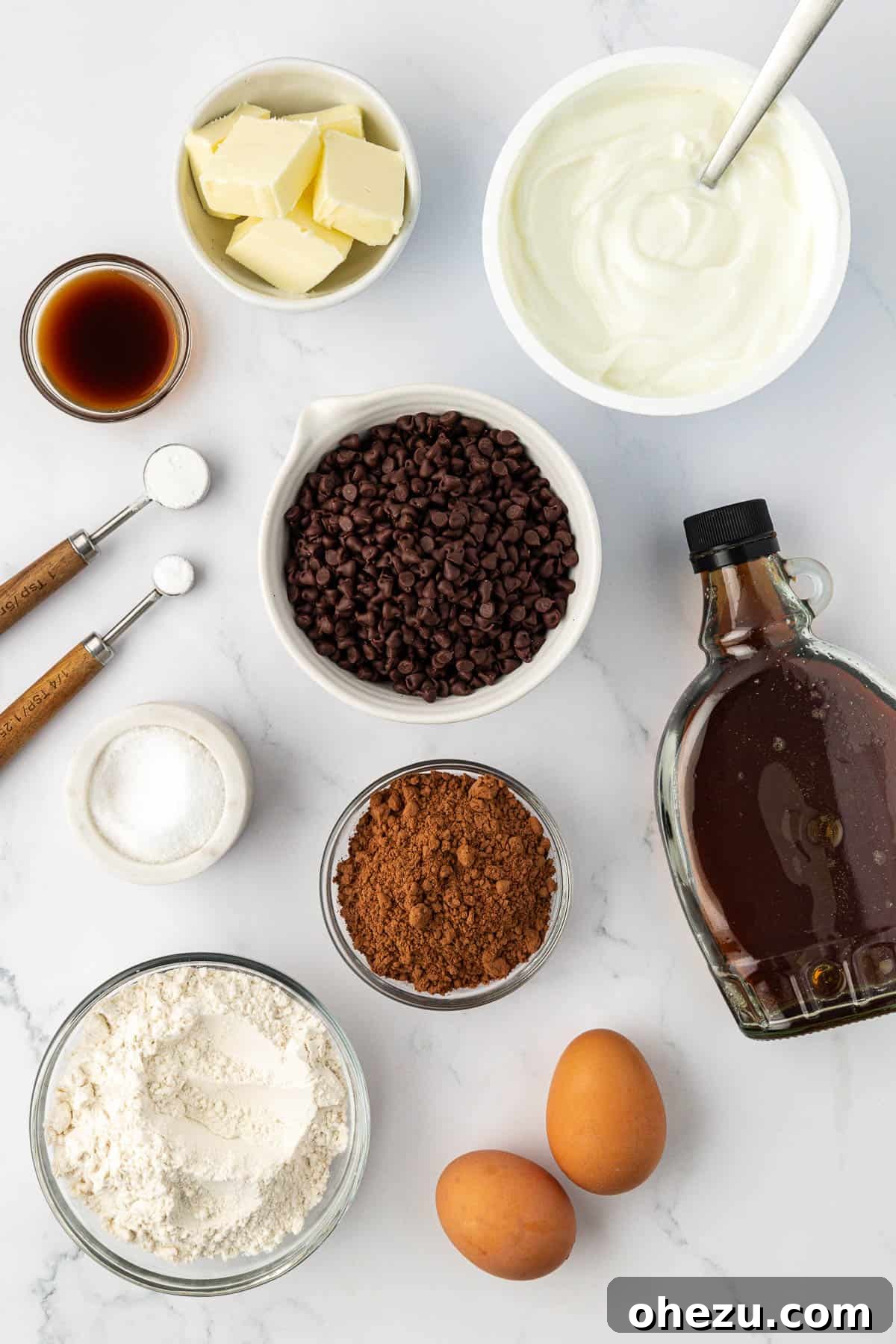 Nourishing Chocolate Mufflets 4 A collection of fresh ingredients laid out, ready to be used for making healthy chocolate muffins, including yogurt, butter, flour, and chocolate chips