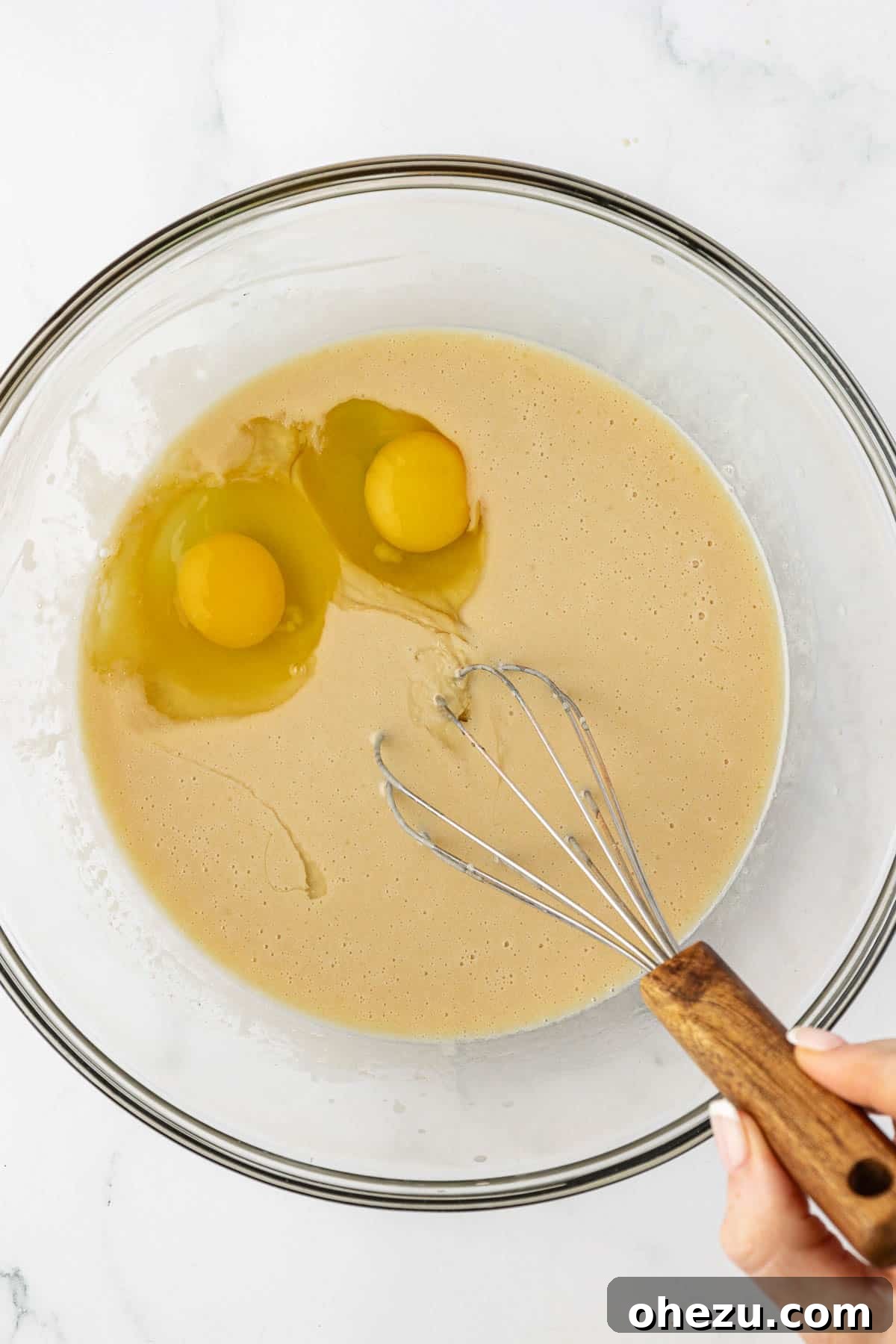 Nourishing Chocolate Mufflets 7 Adding eggs to the wet ingredients mixture, including Greek yogurt, vanilla, butter, and maple syrup