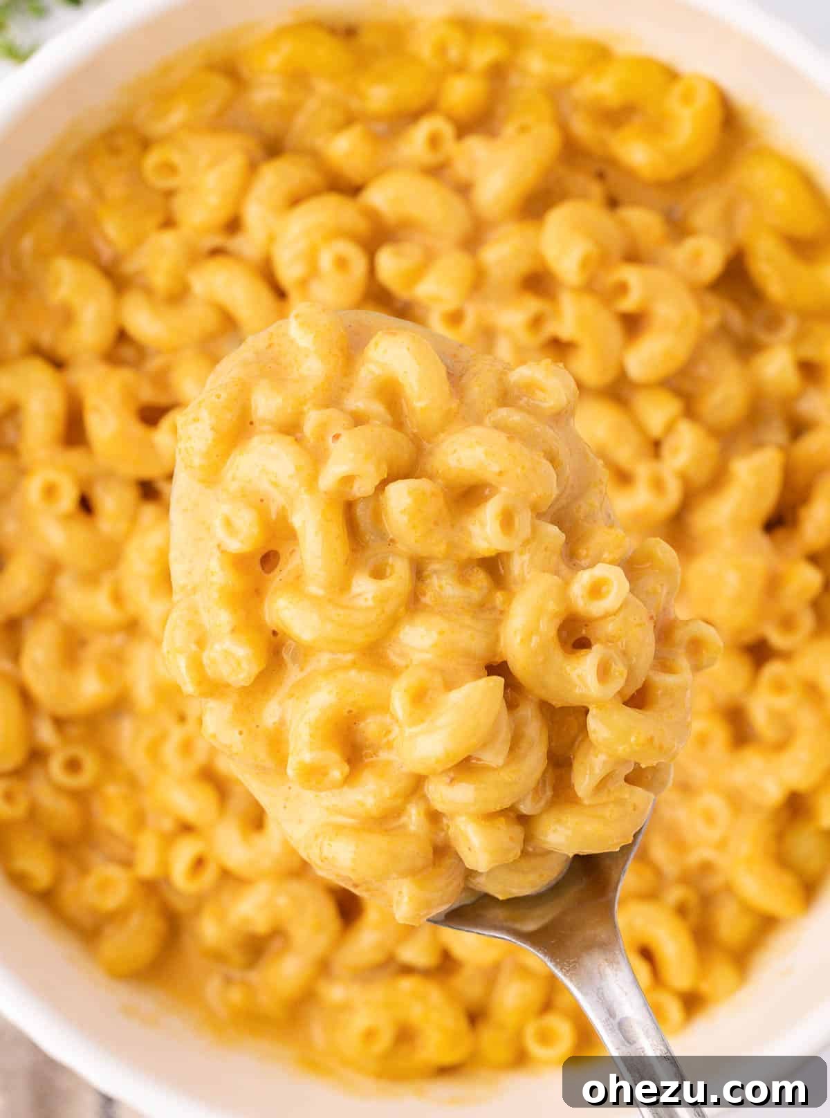 Another enticing view of the butternut squash mac and cheese in a bowl, with a spoon ready for serving.