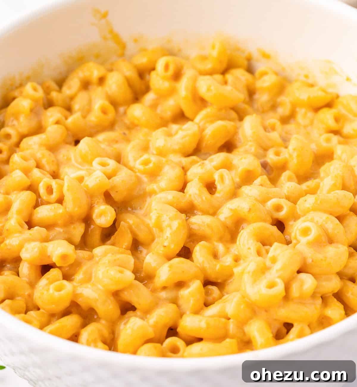 A final close-up of a generous serving of butternut squash mac and cheese in a bowl, highlighting its creamy texture.
