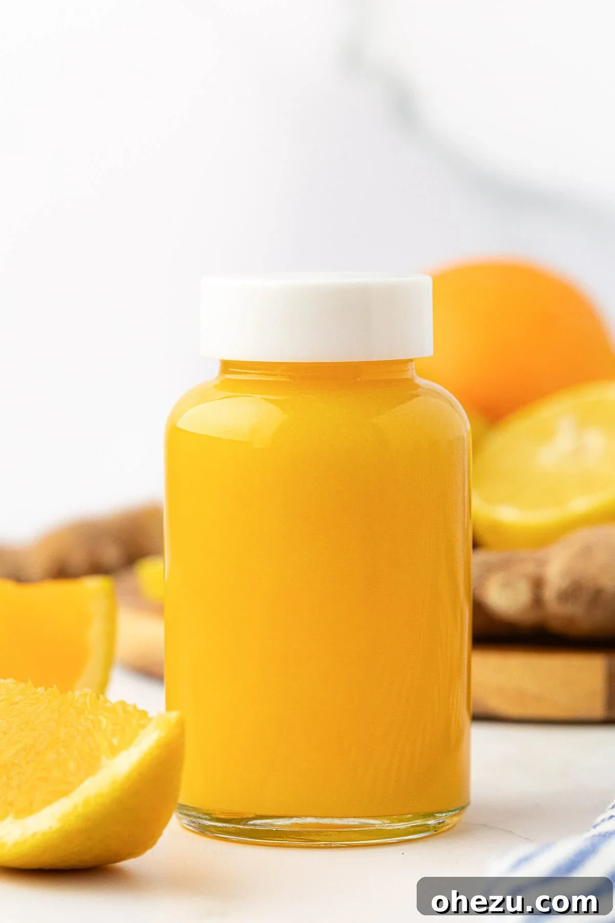 Freshly prepared citrus ginger immunity shots in small glass bottles, ready for consumption.