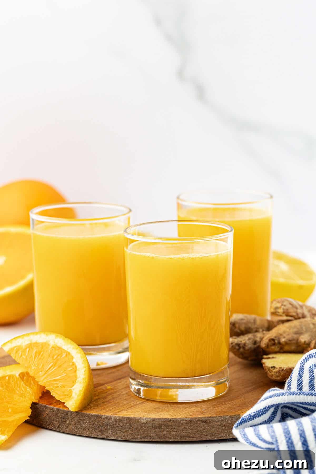 Close-up of a small glass jar filled with citrus ginger juice, showing the vibrant color and freshness.