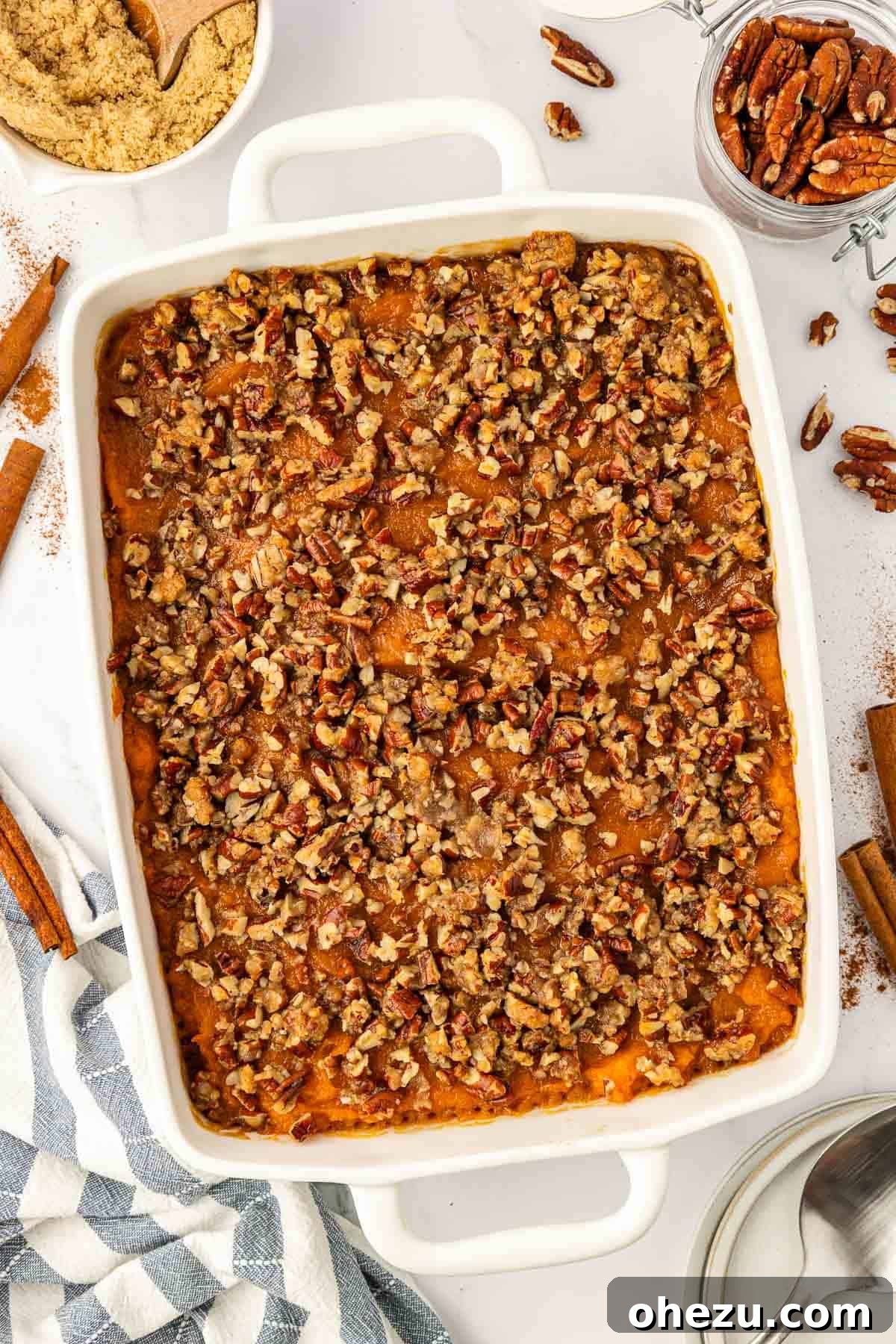 Sweet potato casserole with a golden brown pecan topping in a rustic baking dish, ready to be served at a holiday feast.