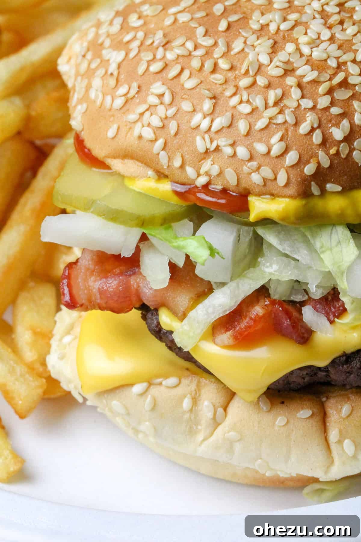 The Ultimate Homemade Travis Scott McDonalds Burger 6 Step-by-step image of assembling the Travis Scott Burger, showing the beef patty, cheese, and bacon placed on the toasted sesame bun.
