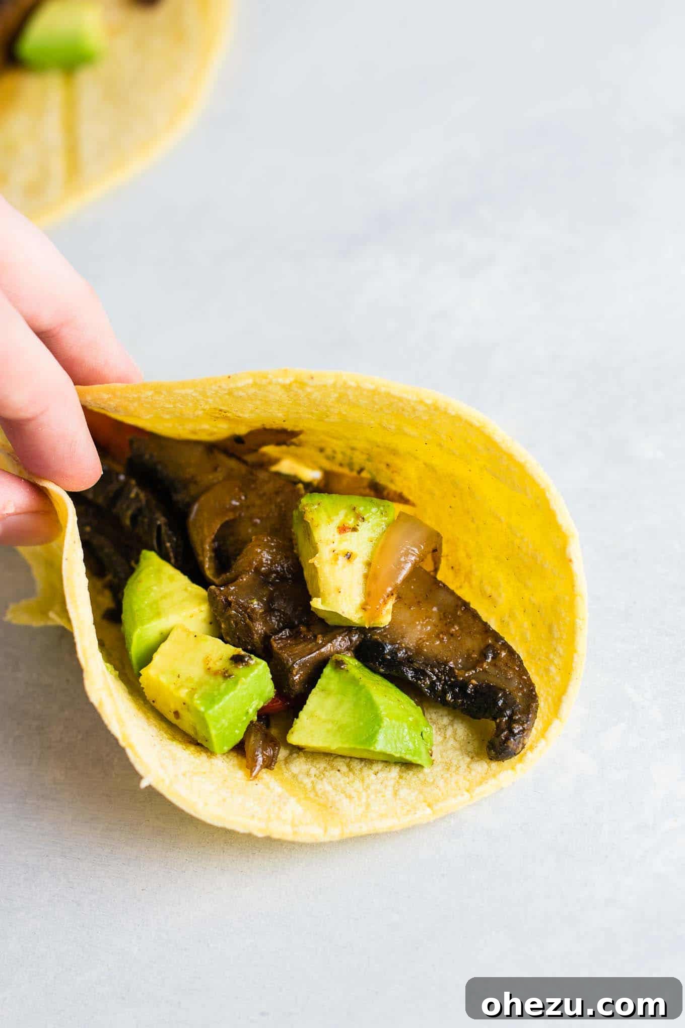 Sizzling Portobello Fajitas 5 A single portobello mushroom fajita expertly wrapped in a corn tortilla, ready to be enjoyed
