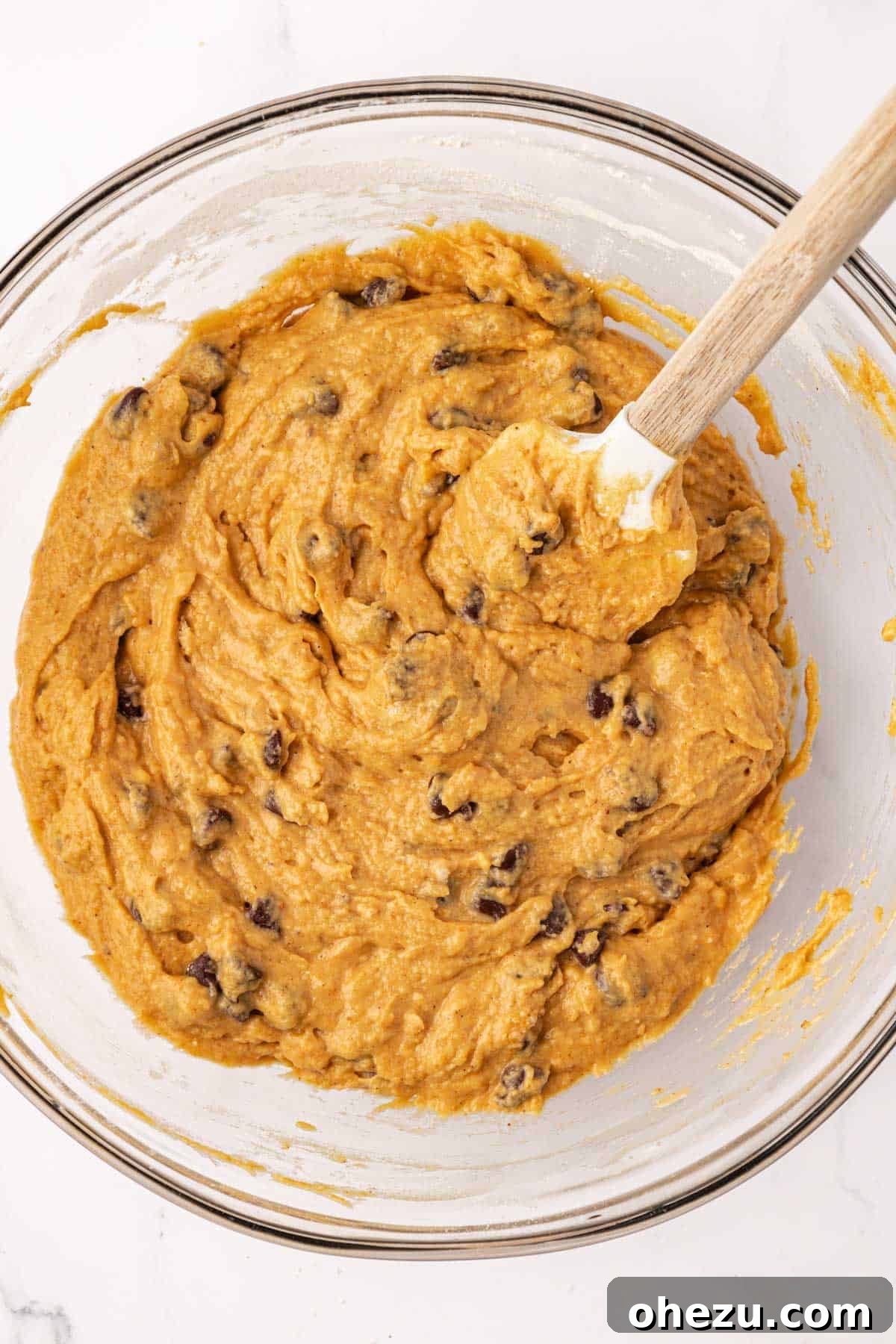 The final Greek yogurt pumpkin muffin batter, with chocolate chips perfectly folded in and evenly distributed, ready to be portioned.