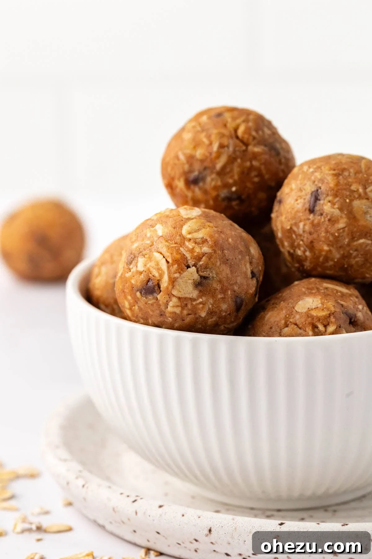 Close-up shot of several oatmeal cookie energy balls, showcasing their texture and the mini chocolate chips embedded within them.